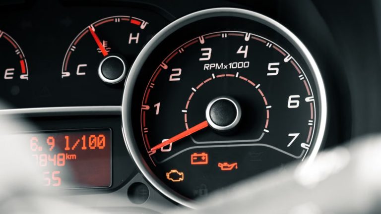 Detailed view of a car dashboard featuring tachometer, odometer, and various indicators.